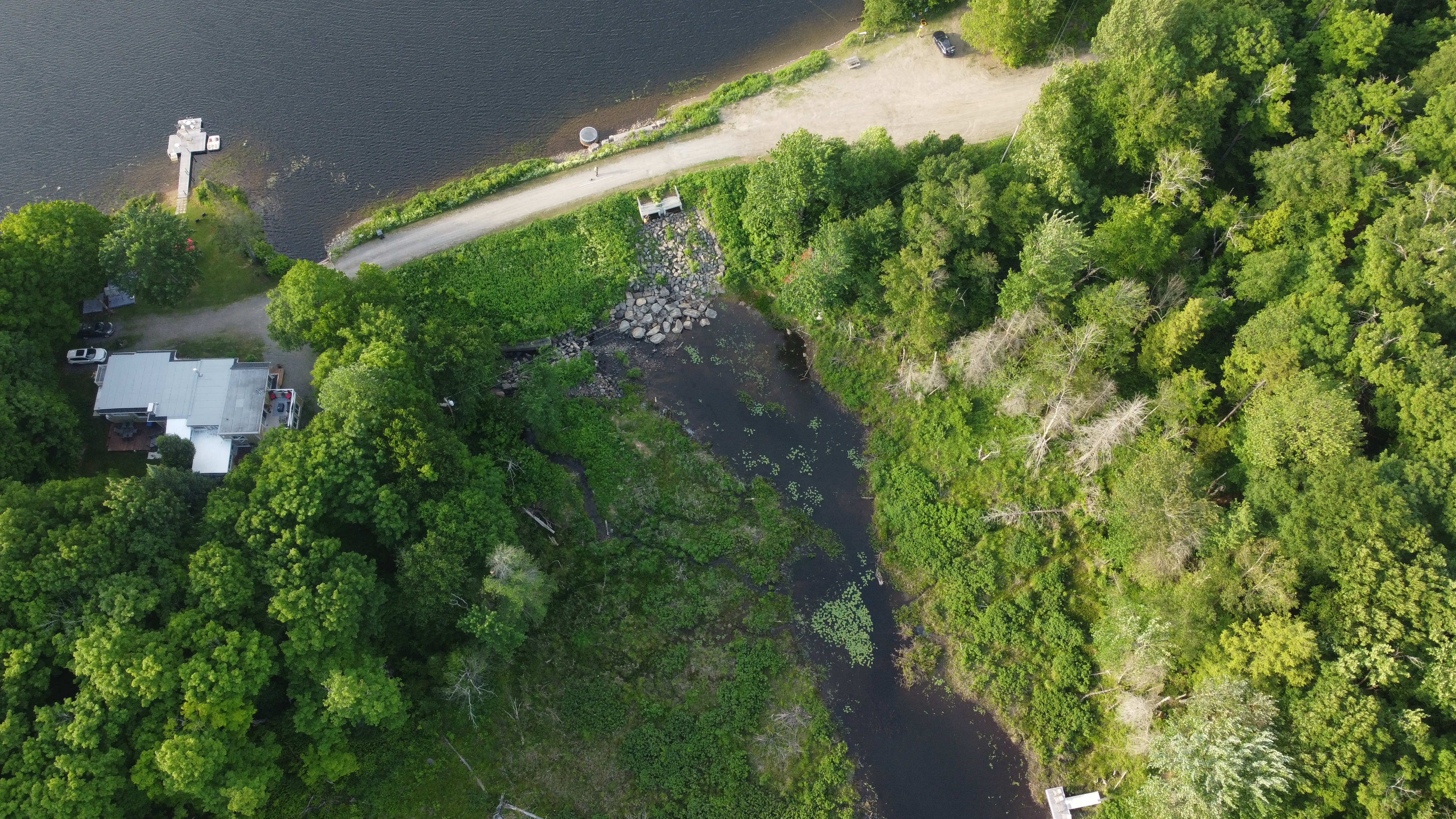 Barrage à faible hauteur avec écoulement visible sur un seuil rocheux dans un environnement naturel au Québec