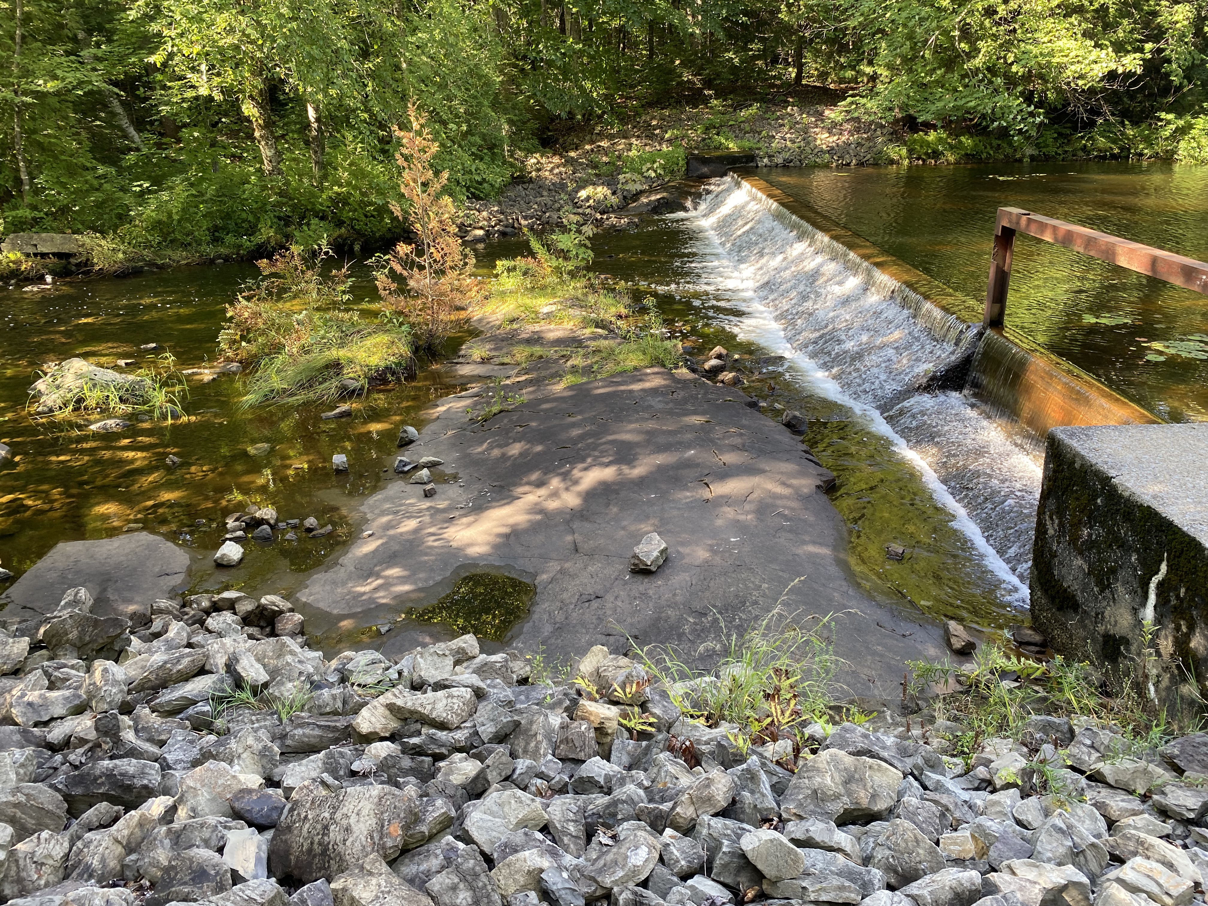 Vue aérienne d’un cours d’eau aménagé avec un ouvrage de retenue et des berges végétalisées au Québec