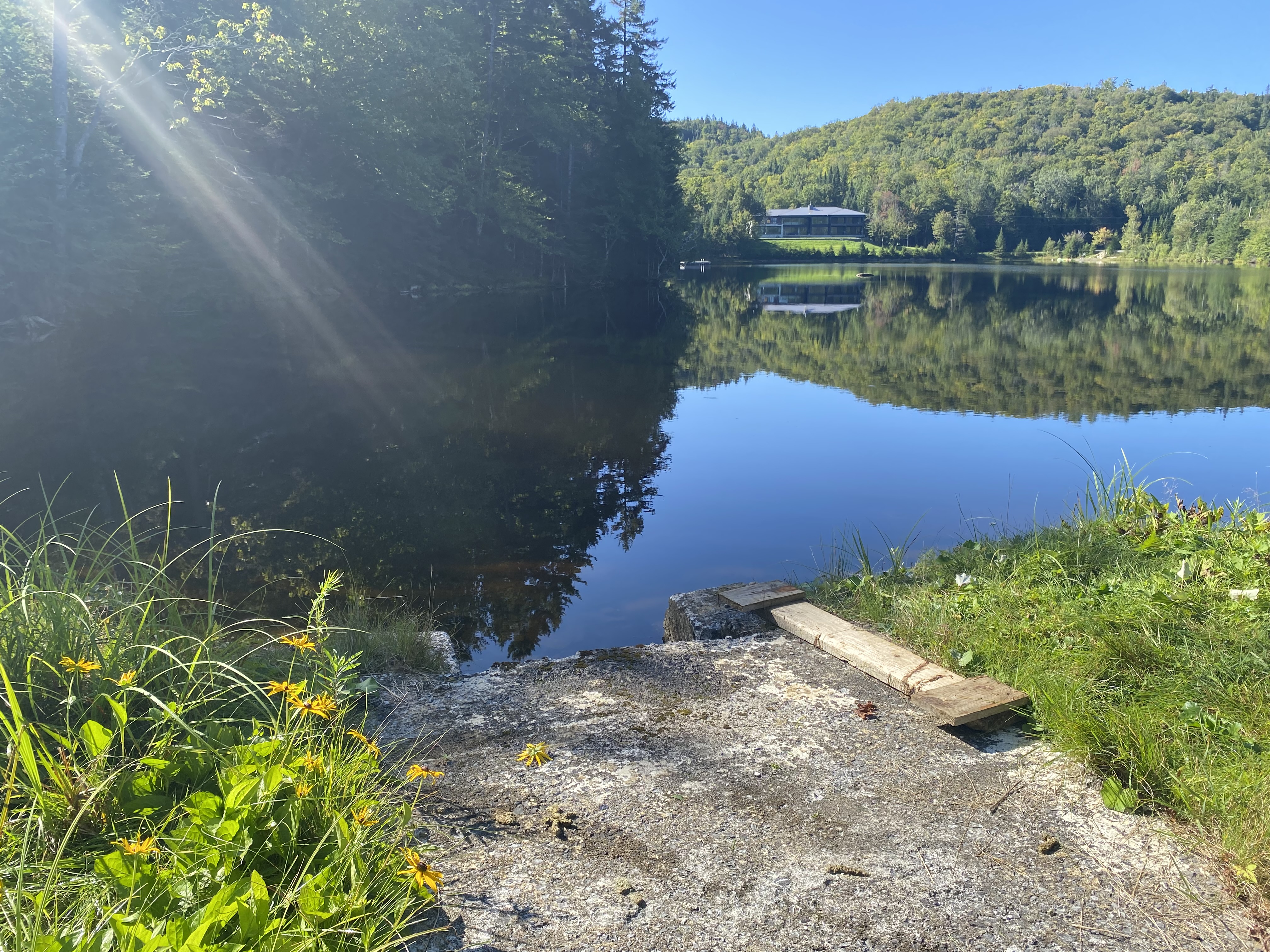 Vue aérienne large d’un réservoir créé par un barrage en zone rurale et forestière au Québec